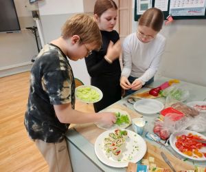 Uczniowie podczas pracy nad kolejnymi etapami przygotowywania zdrowych posiłków.