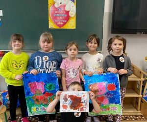 Grupa dzieci prezentująca wykonane prace plastyczne związane z Dniem Misia.