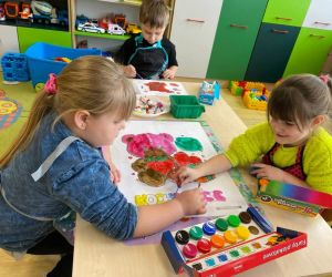 Dzieci wykonujące pracę plastyczną z motywem misia przy użyciu farb.