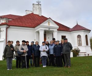 Na pierwszym planie grupa ludzi, w głębi pałac
