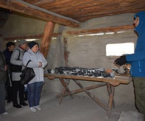 Masłomęcz. Wnętrze chaty gockiego garncarza. Grupa ludzi słucha przewodnika