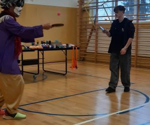 Klaun gra w tenisa z uczniem