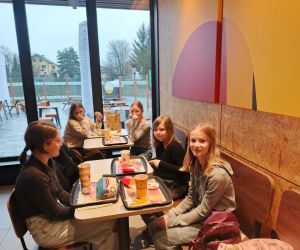 Grupa uczennic klasy 6 siedzących przy stoliku w McDonald’s podczas wspólnego posiłku