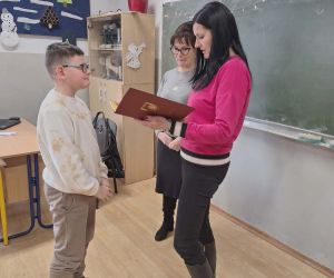Przekazanie dyplomu uczniowi w obecności nauczycielek – uroczystość w szkolnej sali