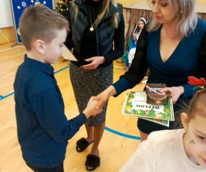 Pani Dyrektor i nauczycielka prowadząca konkurs wręczają dyplom i nagrodę uczniowi klasy czwartej