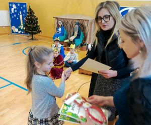 Pani Dyrektor i nauczycielka prowadząca konkurs wręczają dyplom i nagrodę uczennicy klasy drugiej