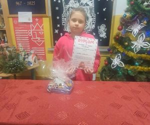 Uczennica trzyma dyplom i nagrodę