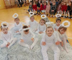  Przedszkolaki w roli aniołków siedzą na materacu