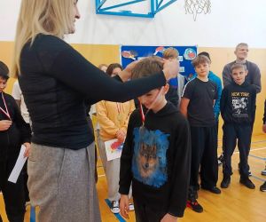 Pani dyrektor zakłada medal uczniowi klasy piątej