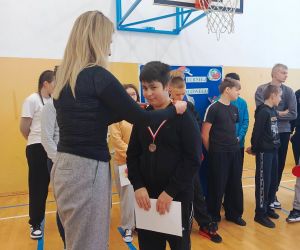 Pani dyrektor zakłada medal uczniowi klasy szóstej