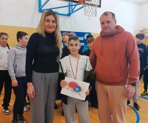 Pani dyrektor, nauczyciel wychowania fizycznego i uczeń klasy piątej z dyplomem pamiątkowym i medalem