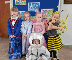 Cztery dziewczynki i chłopiec z oddziału przedszkolnego w kolorowych przebraniach