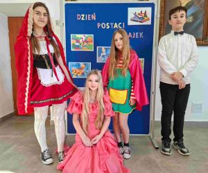 Uczniowie klasy piątej i siódmej na tle tablicy dekoracyjnej