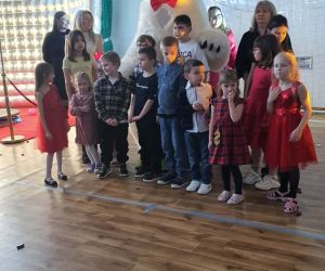 uczniowie na zdjęciu z białym misiem