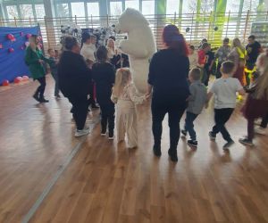 uczniowie tańczą z białym misiem