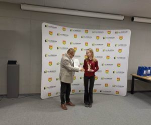 Uczennica odbiera nagrodę podczas uroczystego wręczenia dyplomów dla uczestników turnieju.