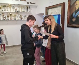 Pani Dyrektor i nauczycielka języka polskiego wręczają dyplomy szkolnym mistrzom ortografii