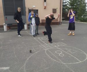 Uczniowie grają w dziada na placu szkolnym