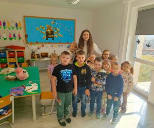 Uczennica klasy siódmej z dziećmi z oddziału przedszkolnego
