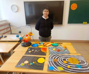 Uczeń klasy szóstej przy modelach Układu Słonecznego