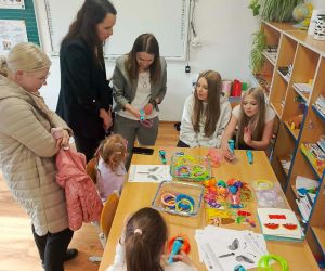 Nauczycielki pokazują dzieciom przy stoliku jak używać długopisów 3D