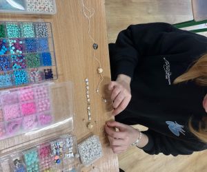 uczennica robi bransoletkę z koralików