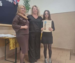 Uczennica prezentuje dyplom zdobyty w konkursie, stoi wraz z organizatorkami wydarzenia.