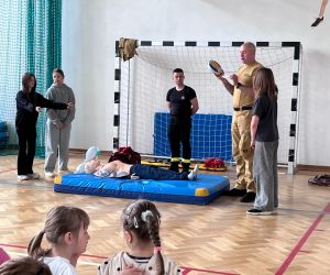 uczniowie podczas ćwiczeń ze strażakami z udzielania pierwszej pomocy