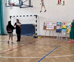 wręczenie dyplomów i nagród w konkursie plastycznym, w tle prace konkursowe