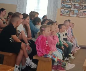 Dzieci i uczniowie z zainteresowaniem oglądają przedstawienie teatralne.