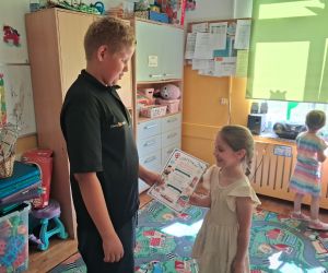 uczeń wręcza dyplom dziewczynce