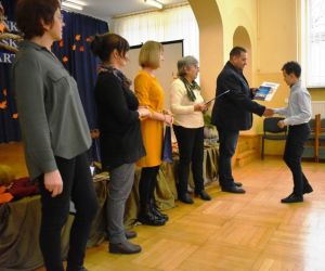 Grupa ludzi przy scenie, wręczanie nagród.