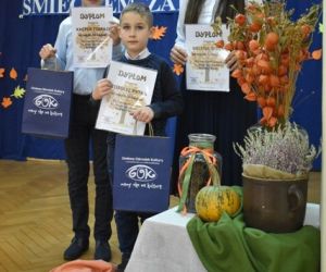 Dzieci na scenie prezentują dyplomy, które otrzymały w konkursie
