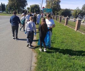 Uczniowie zbierają śmieci przy cmentarzu
