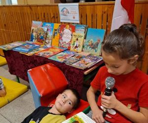 Uczennica czyta bajkę, dziecko leży i słucha