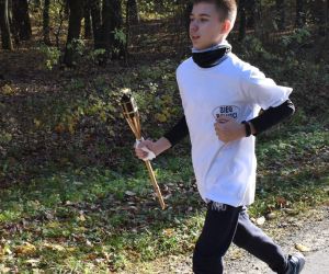 Las. Droga. Jedna osoba biegnie z pochodnią