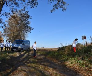 Droga. Pięć osób, samochód, po prawej cmentarz