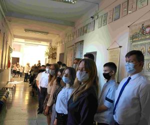 Uczniowie klasy VIII w strojach galowych i maskach, z przypiętymi kotylionami w barwach narodowych.