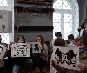 Uczniowie prezentują swoje kartki na których widać przyszłość zapisaną w kleksach