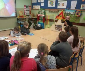 Uczniowie oglądają teatrzyk kamishibai