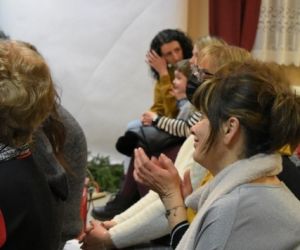 Osoby siedzą i biją brawa.