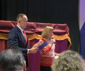 Osoby przemawiają na środku sceny.