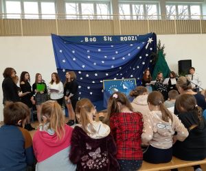 Uczniowie rozpoczynają jasełka, za nimi sceneria świąteczna