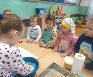 dziewczynka mięsi ciasto, dzieci się przyglądają