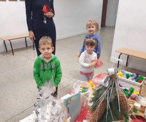 Dyrektor szkoły i troje uczniów przy stole z dekoracjami świątecznymi