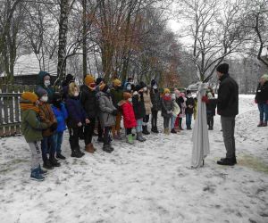 Uczniowie słuchają opowieści kolędnika trzymającego kukłę turonia