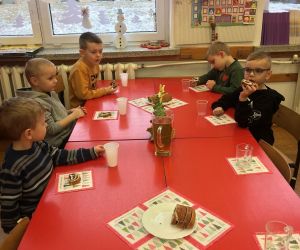 Dzieci siedzą przy stole.