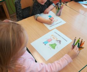 Dzieci wykonują pracę plastyczną „ Dzień babci i dziadka”.