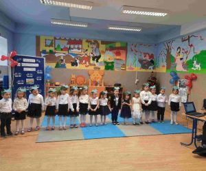 Przedszkolaki w siało-czarnych strojach ustawione w szeregu w sali przedszkolnej