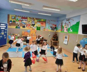 Grupa przedszkolaków tańczy w sali przedszkolnej